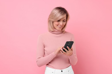 Photo of Happy woman with phone on pink background