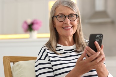 Senior woman using mobile phone at home