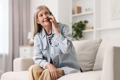 Senior woman talking on phone at home