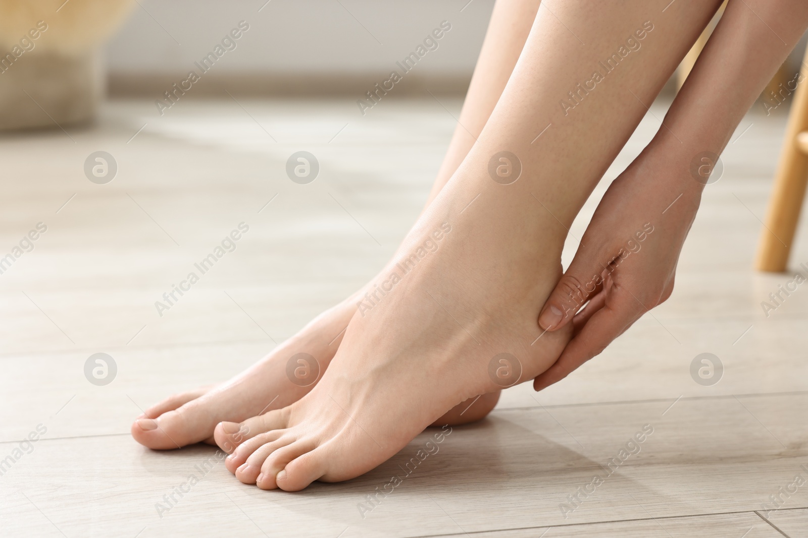 Photo of Closeup view of woman`s groomed feet after care procedure on floor