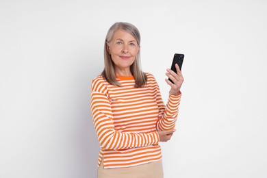 Photo of Senior woman with phone on light grey background