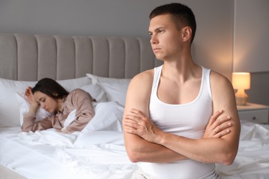 Offended couple ignoring each other in bedroom. Relationship problem