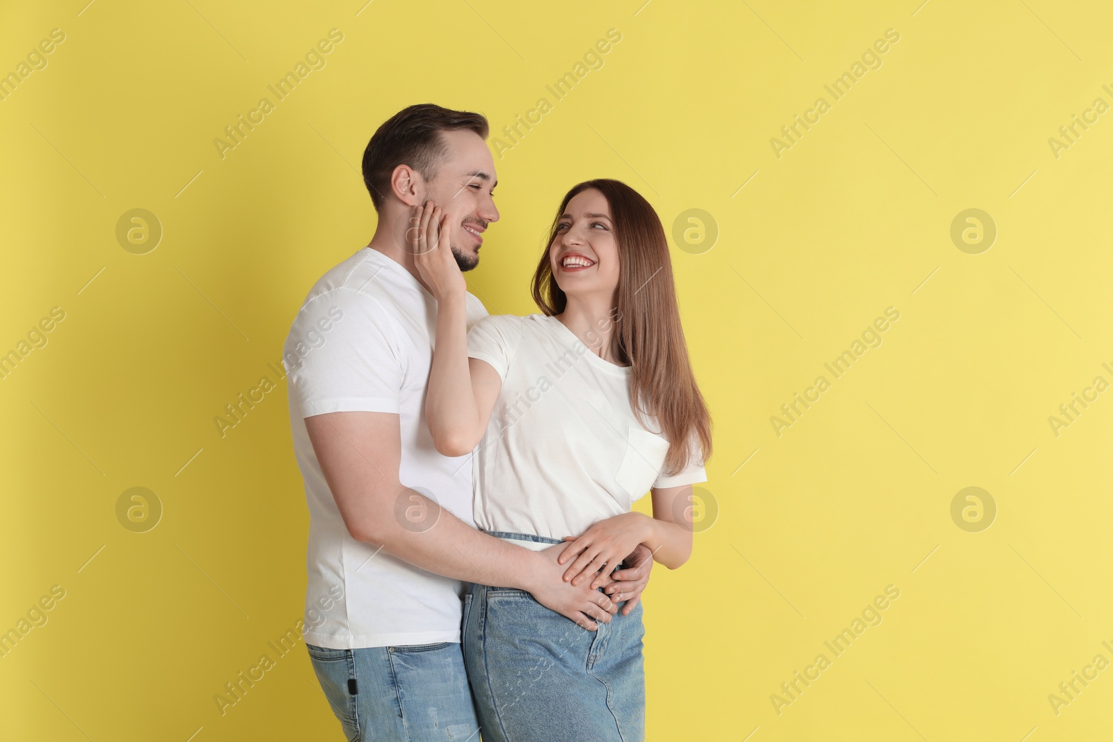 Photo of Happy couple hugging on yellow background. Strong relationship