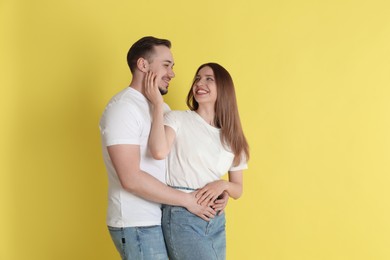 Happy couple hugging on yellow background. Strong relationship