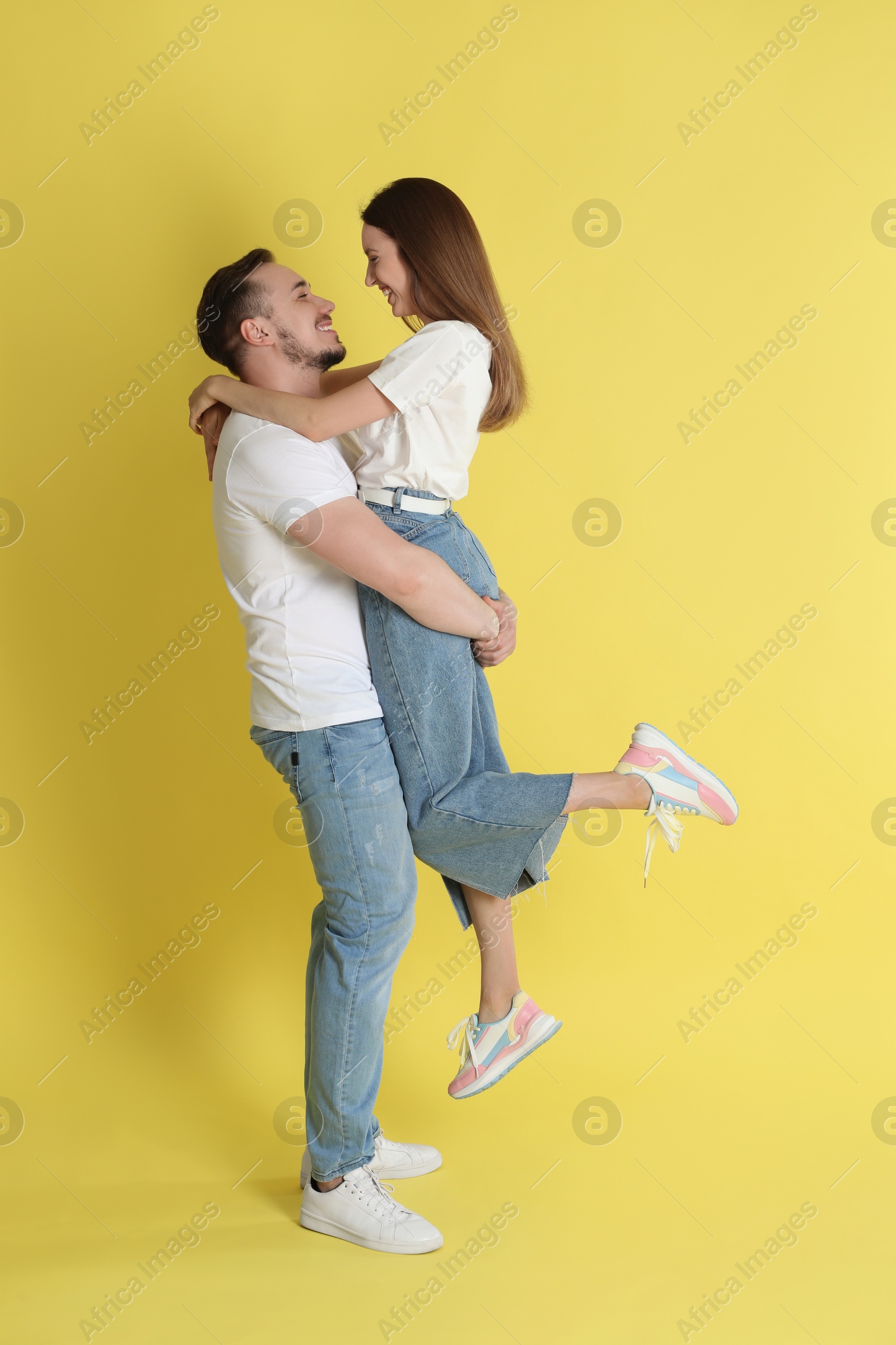 Photo of Happy couple hugging on yellow background. Strong relationship