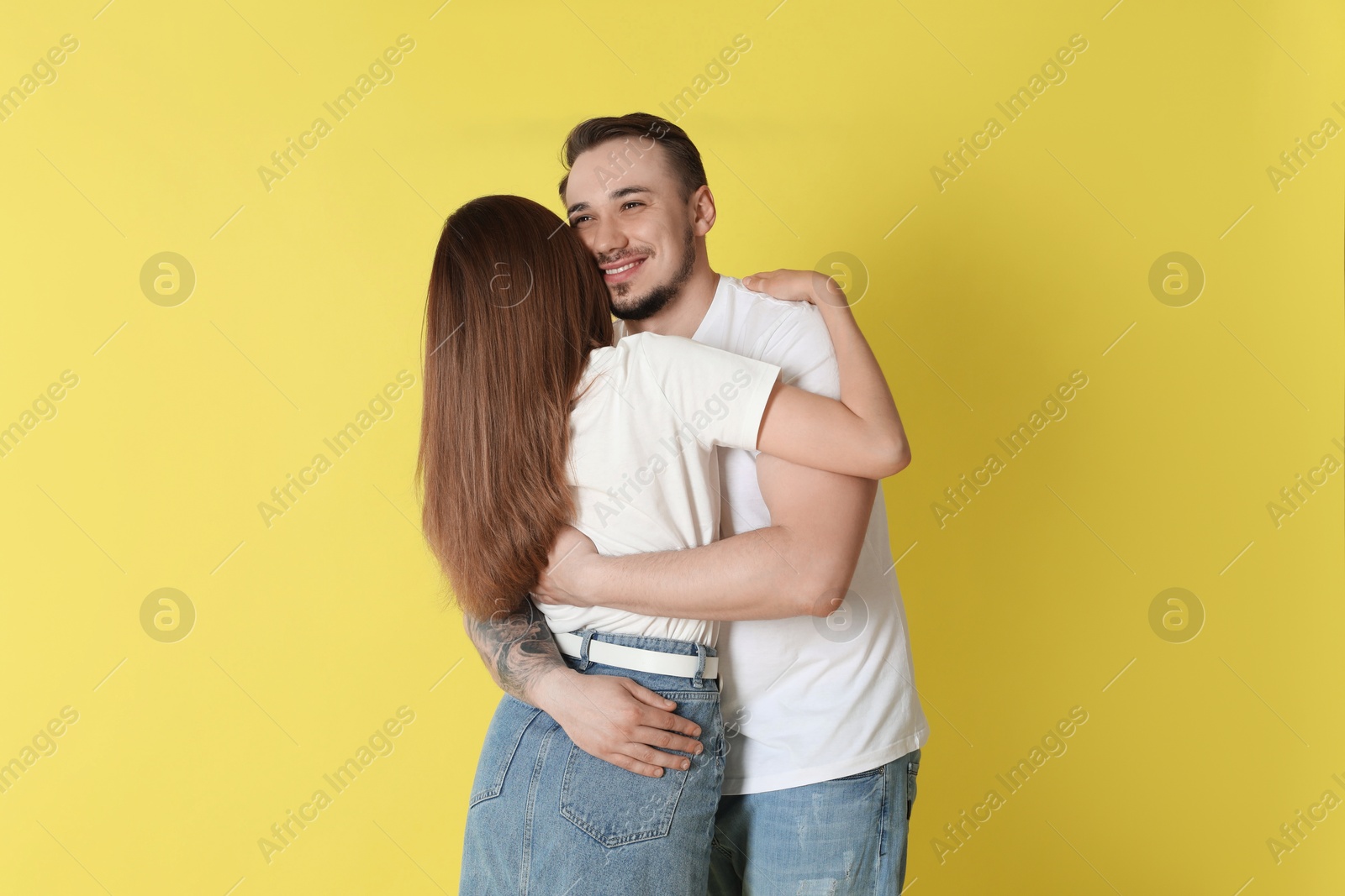 Photo of Happy couple hugging on yellow background. Strong relationship