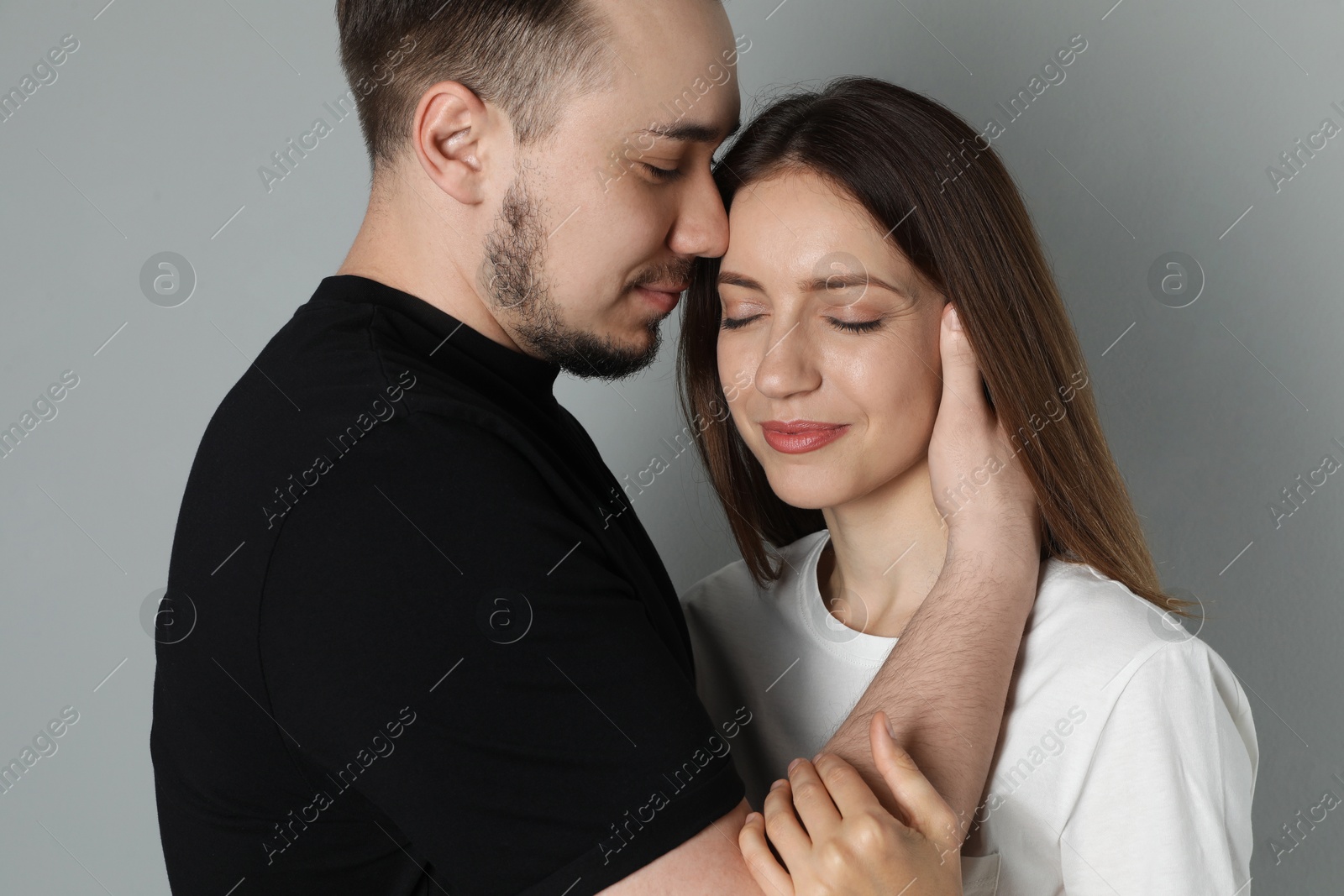 Photo of Lovely couple enjoying each other on grey background