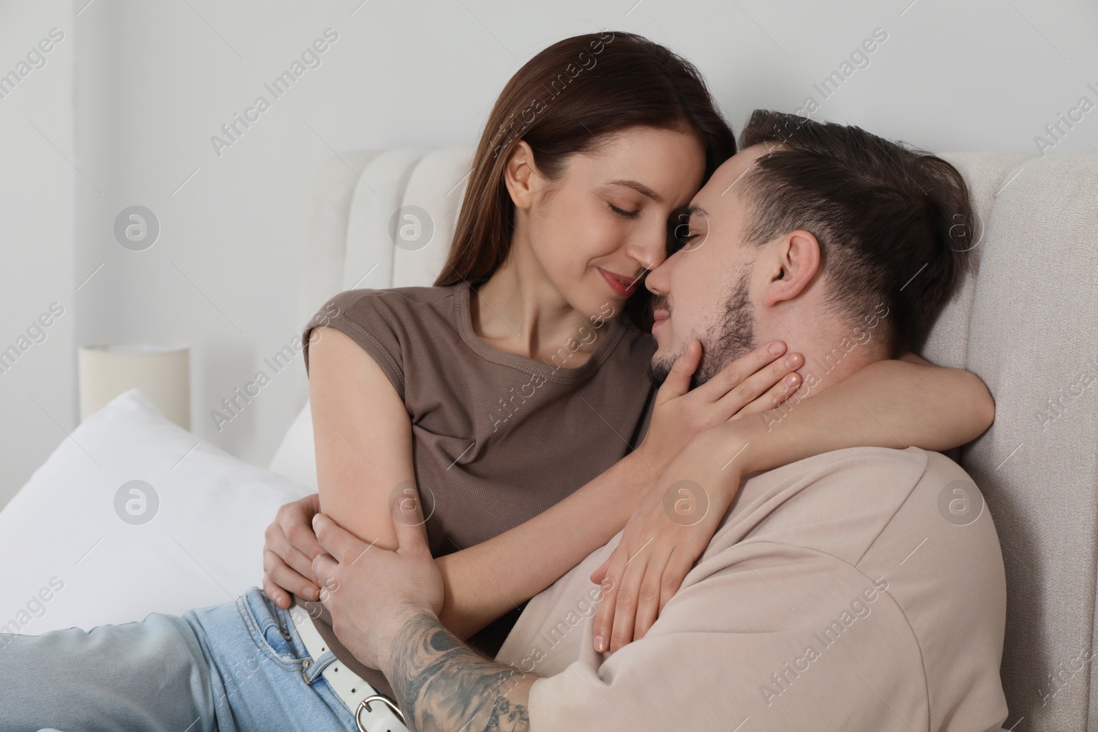 Photo of Lovely couple hugging on bed at home