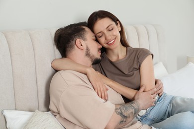 Photo of Happy couple hugging on bed at home