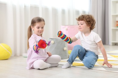 Cute little children playing with funny sock puppets in kindergarten