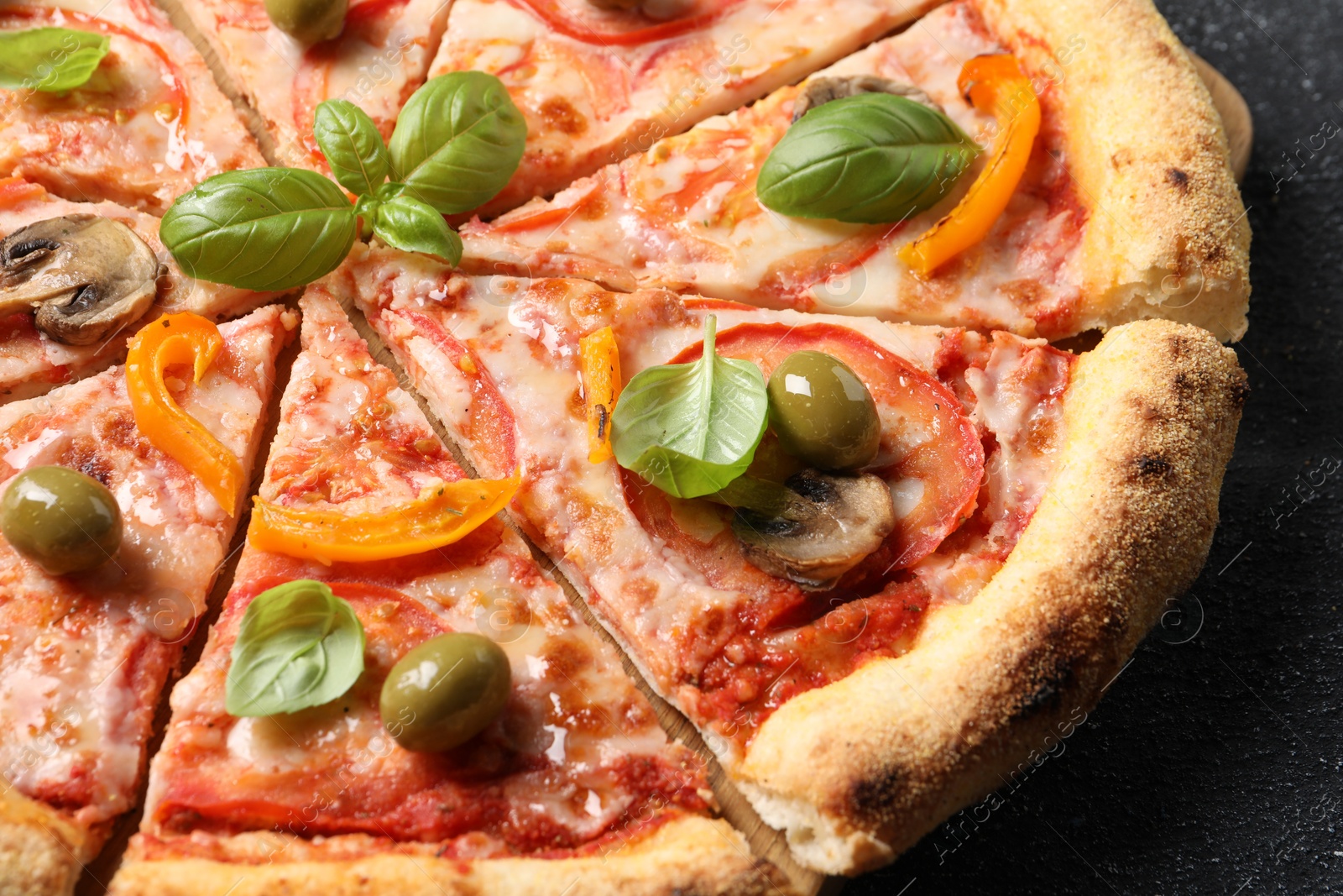 Photo of Cut delicious vegetarian pizza on grey table, closeup