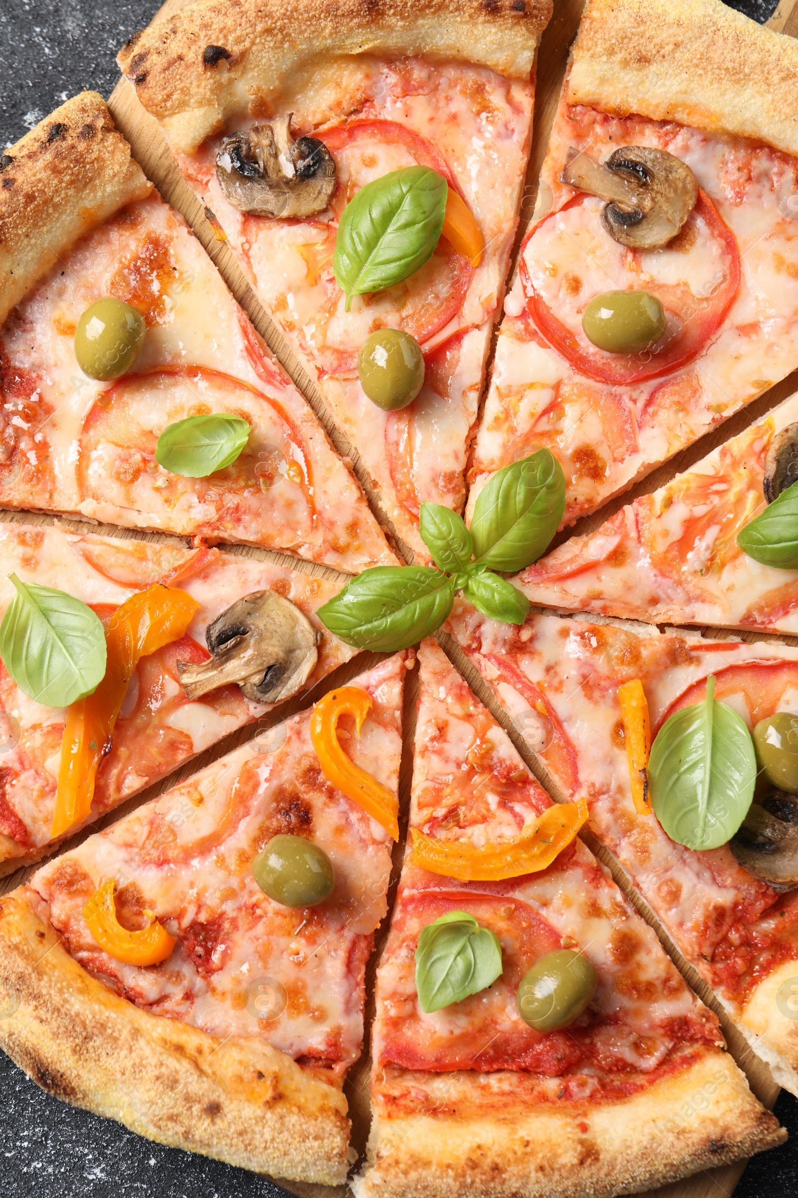 Photo of Cut delicious vegetarian pizza on grey table, top view