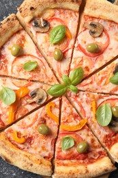 Photo of Cut delicious vegetarian pizza on grey table, top view