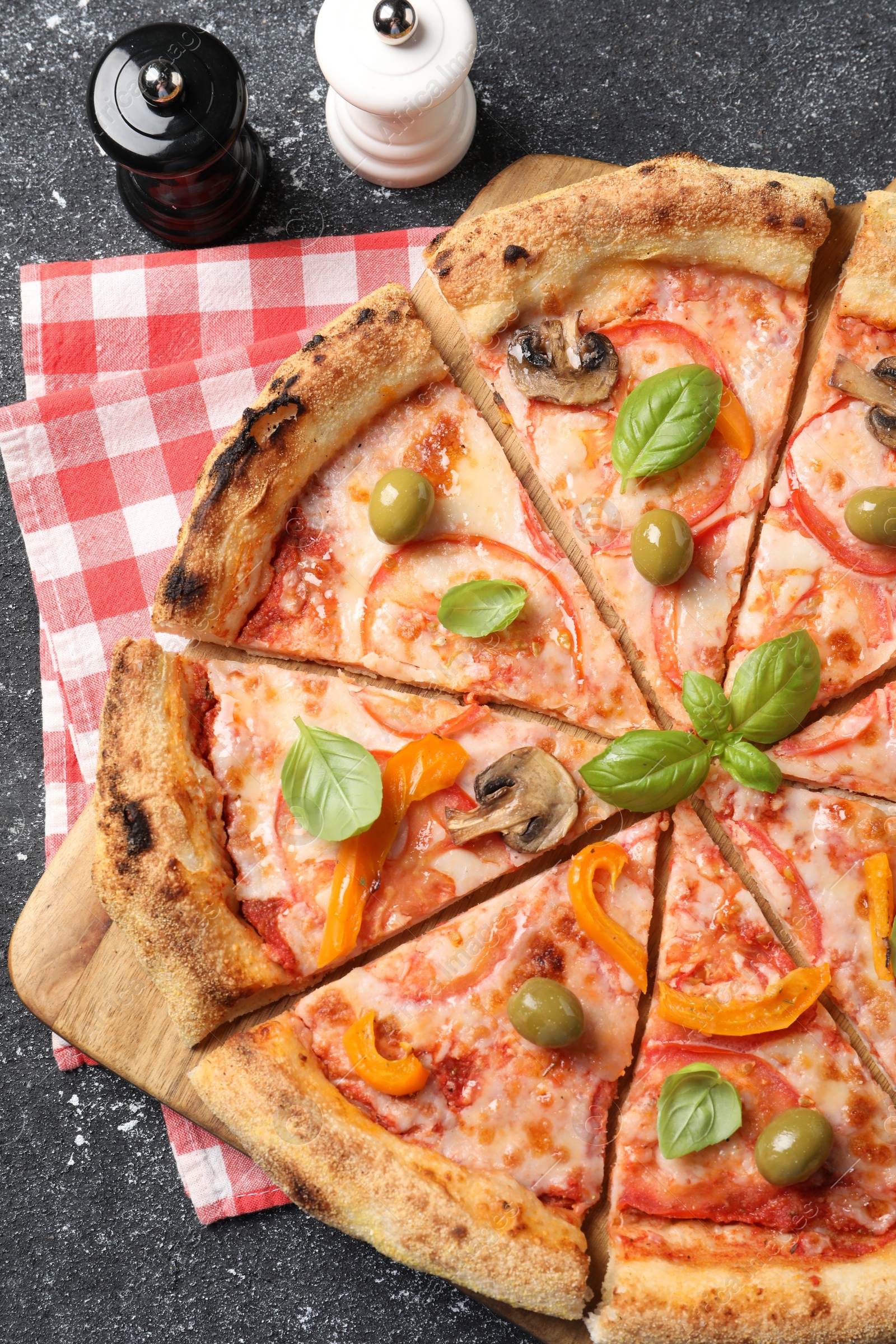 Photo of Cut delicious vegetarian pizza and spices on grey table, top view