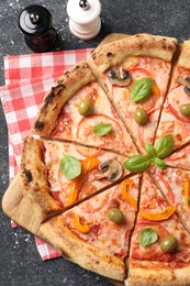 Photo of Cut delicious vegetarian pizza and spices on grey table, top view