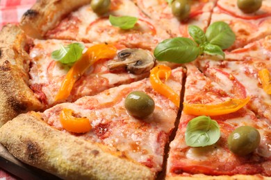 Photo of Cut delicious vegetarian pizza on table, closeup