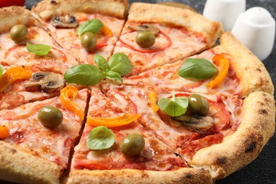 Photo of Cut delicious vegetarian pizza on table, closeup