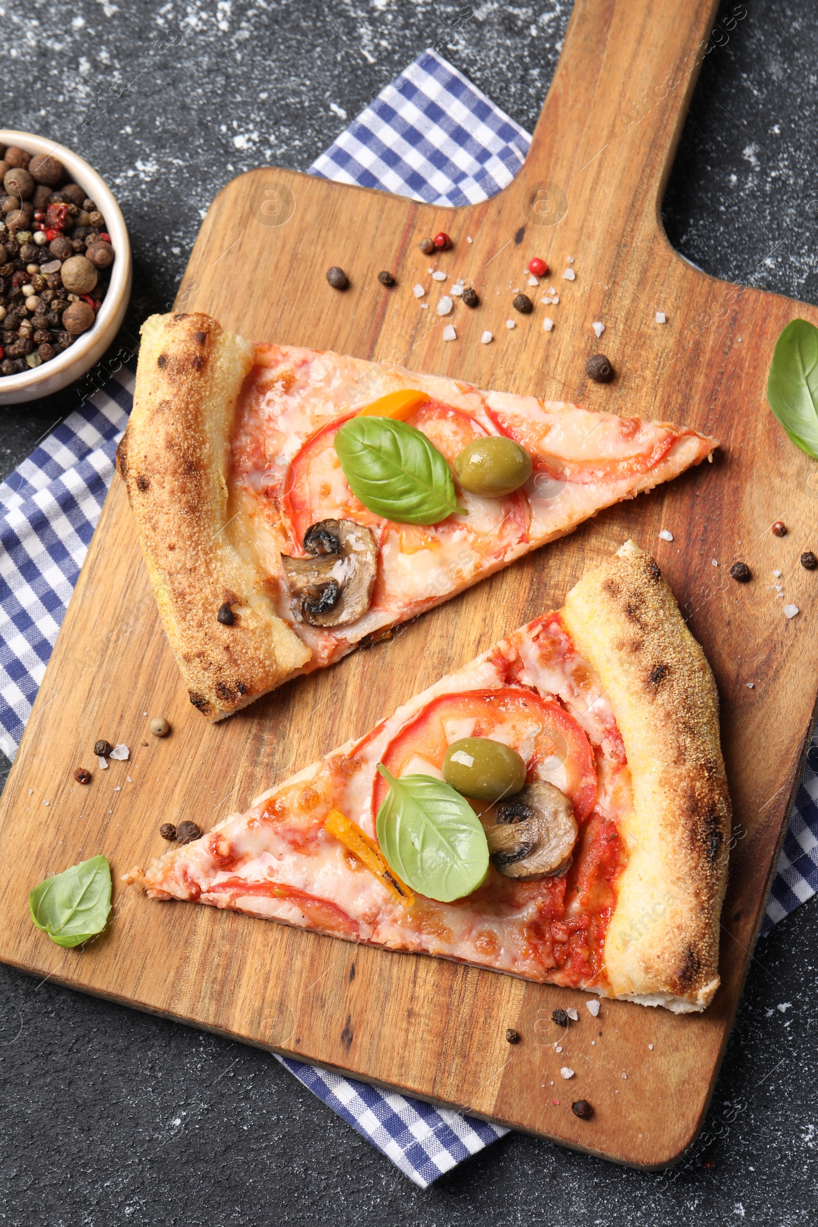 Photo of Cut delicious vegetarian pizza and spices on grey table, top view