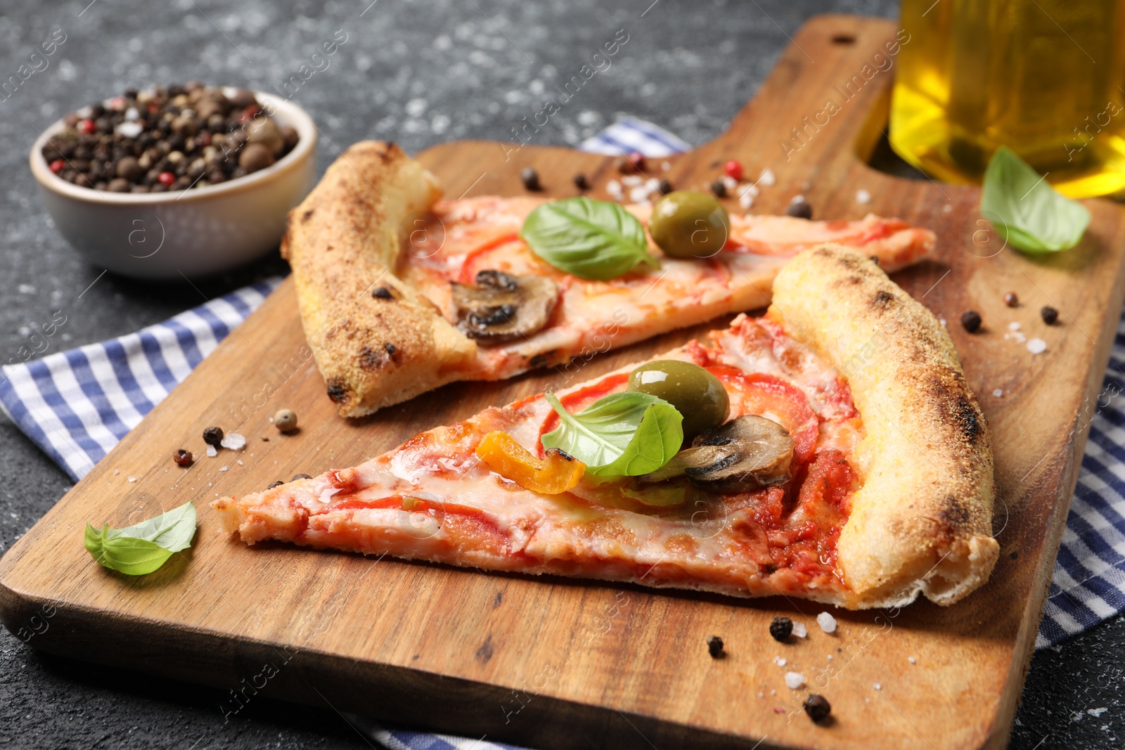 Photo of Cut delicious vegetarian pizza and spices on table