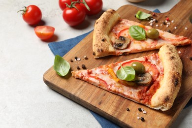 Photo of Cut delicious vegetarian pizza and tomatoes on light grey table