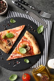 Photo of Cut delicious vegetarian pizza, cutlery and ingredients on grey table, top view