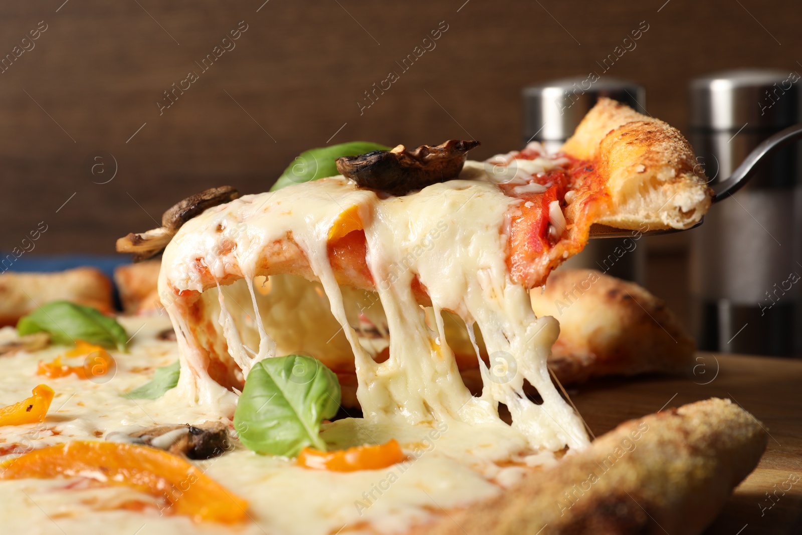 Photo of Taking piece of delicious vegetarian pizza at table, closeup