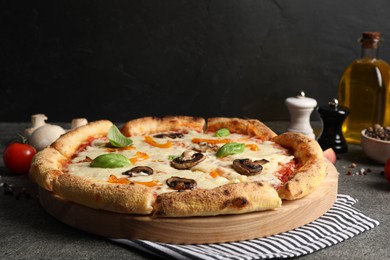 Photo of Delicious vegetarian pizza and ingredients on grey table