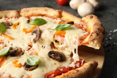 Photo of Taking piece of delicious vegetarian pizza at table, closeup