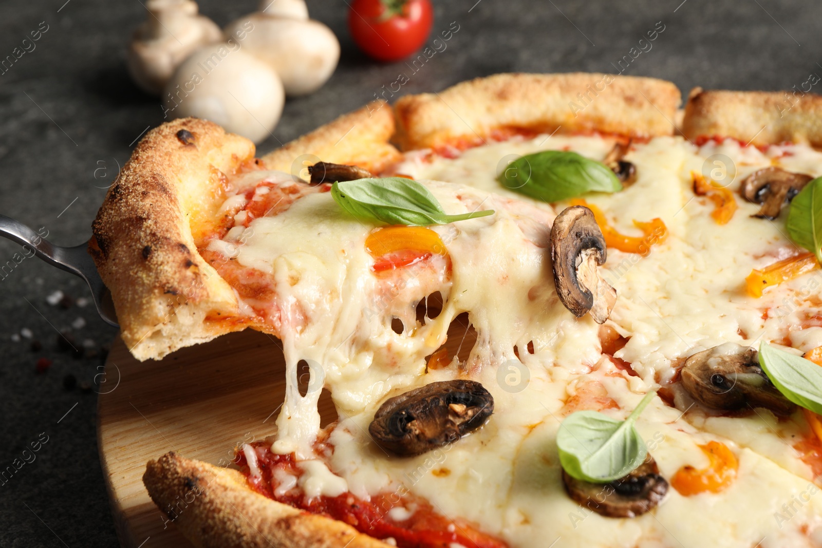 Photo of Taking piece of delicious vegetarian pizza at table, closeup