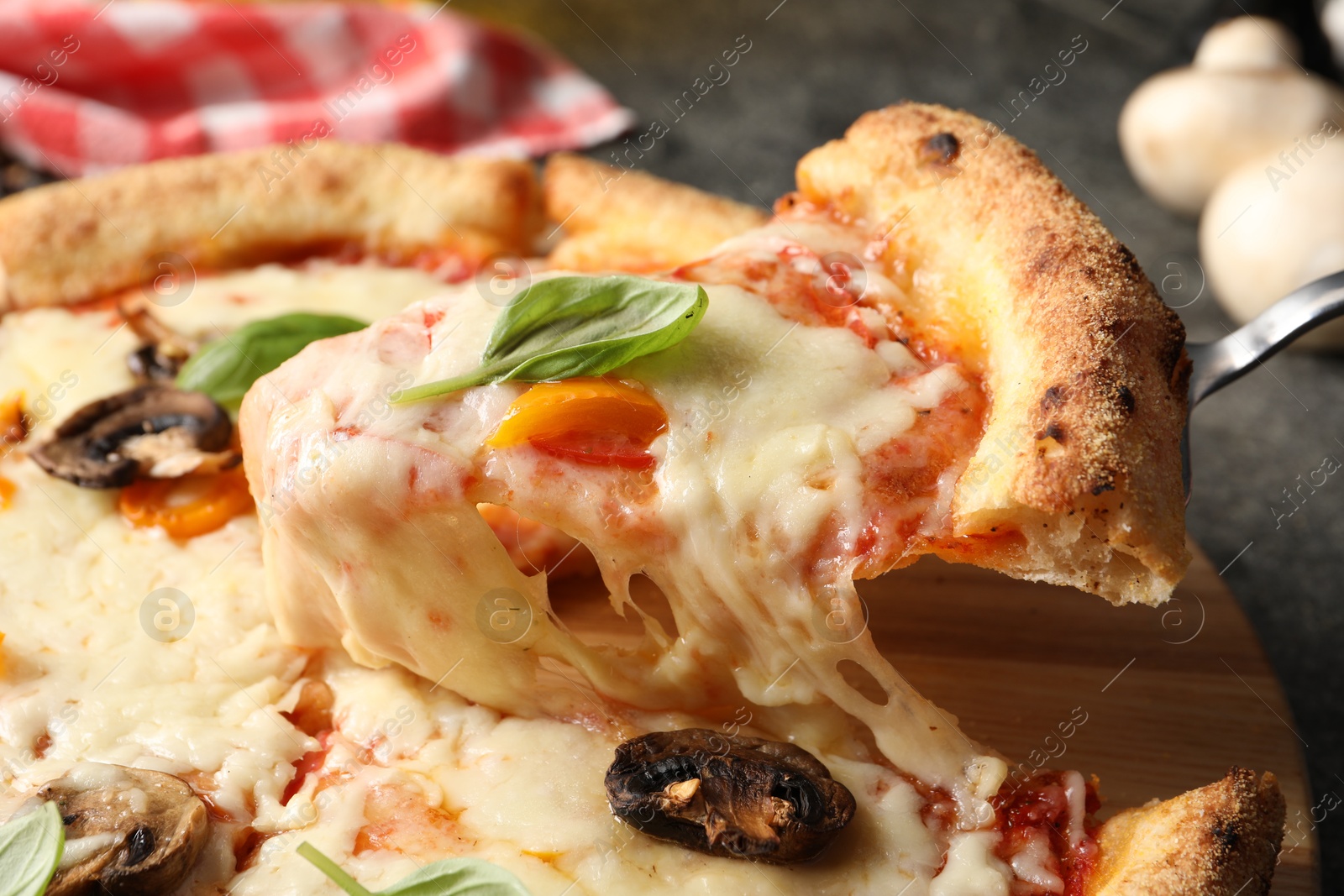 Photo of Taking piece of delicious vegetarian pizza at table, closeup