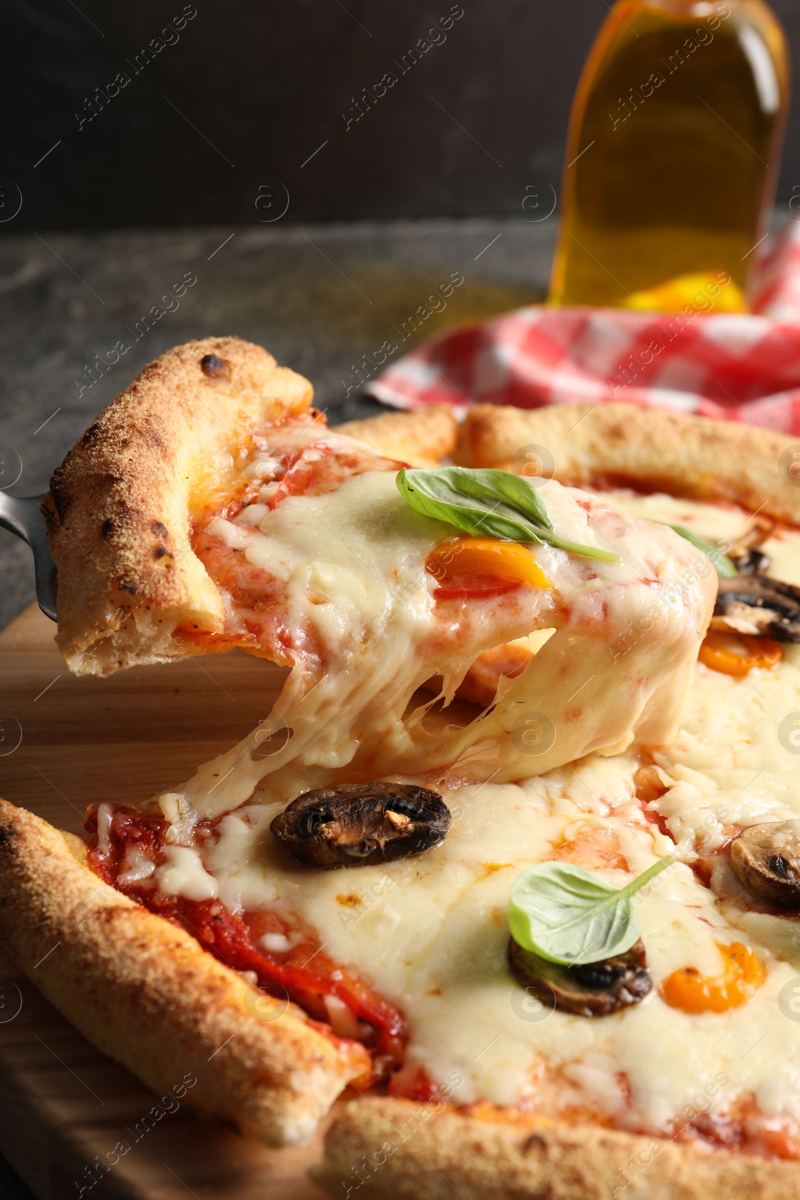 Photo of Taking piece of delicious vegetarian pizza at table, closeup