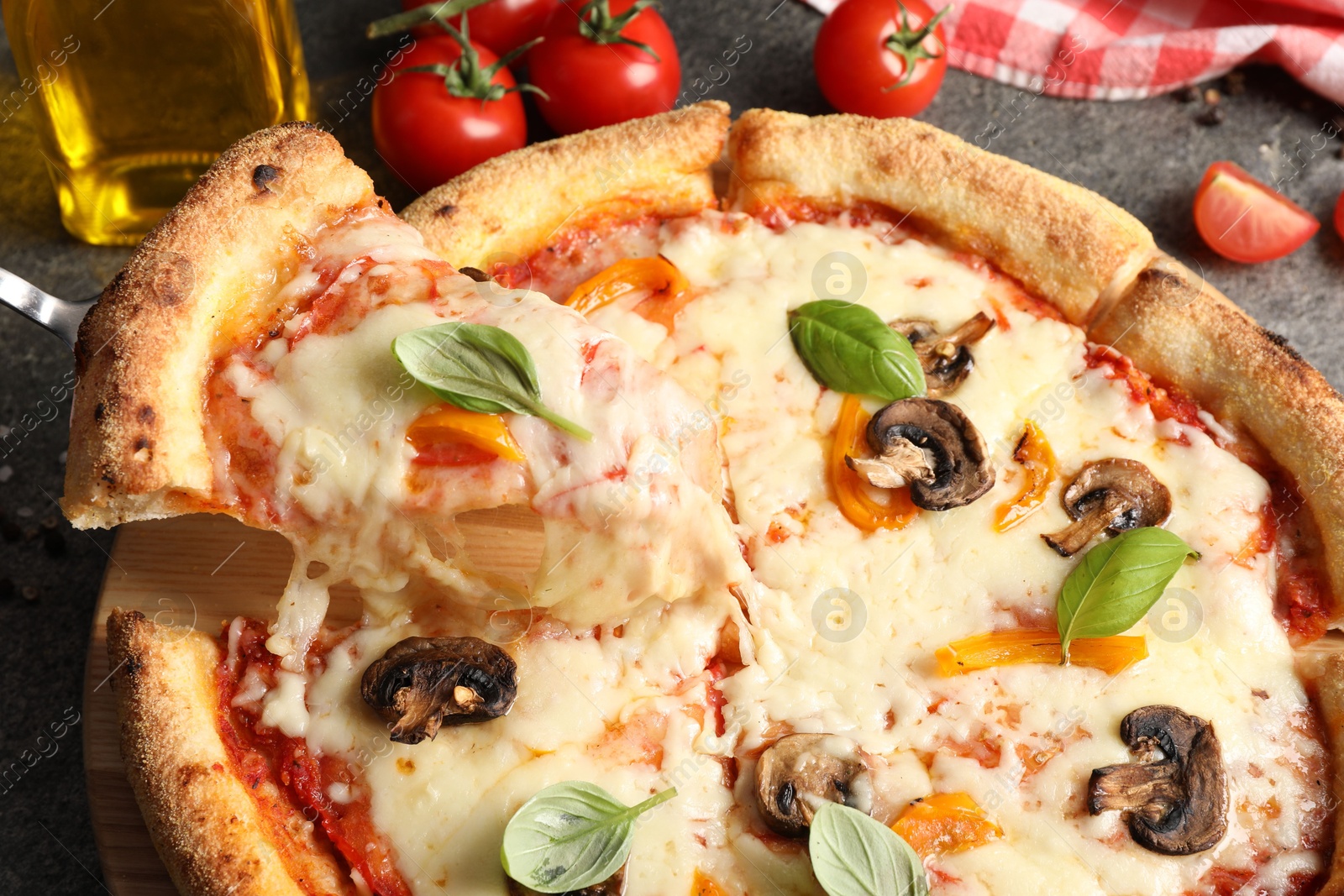 Photo of Taking piece of delicious vegetarian pizza at table, closeup