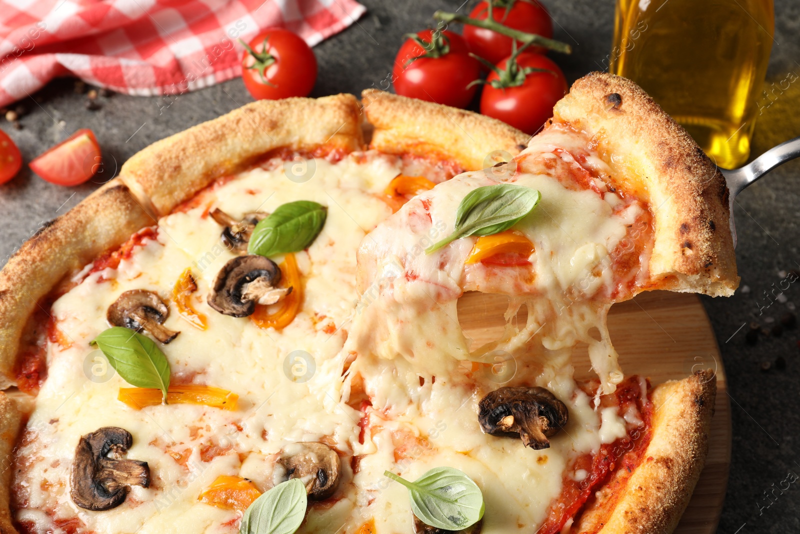 Photo of Taking piece of delicious vegetarian pizza at table, closeup