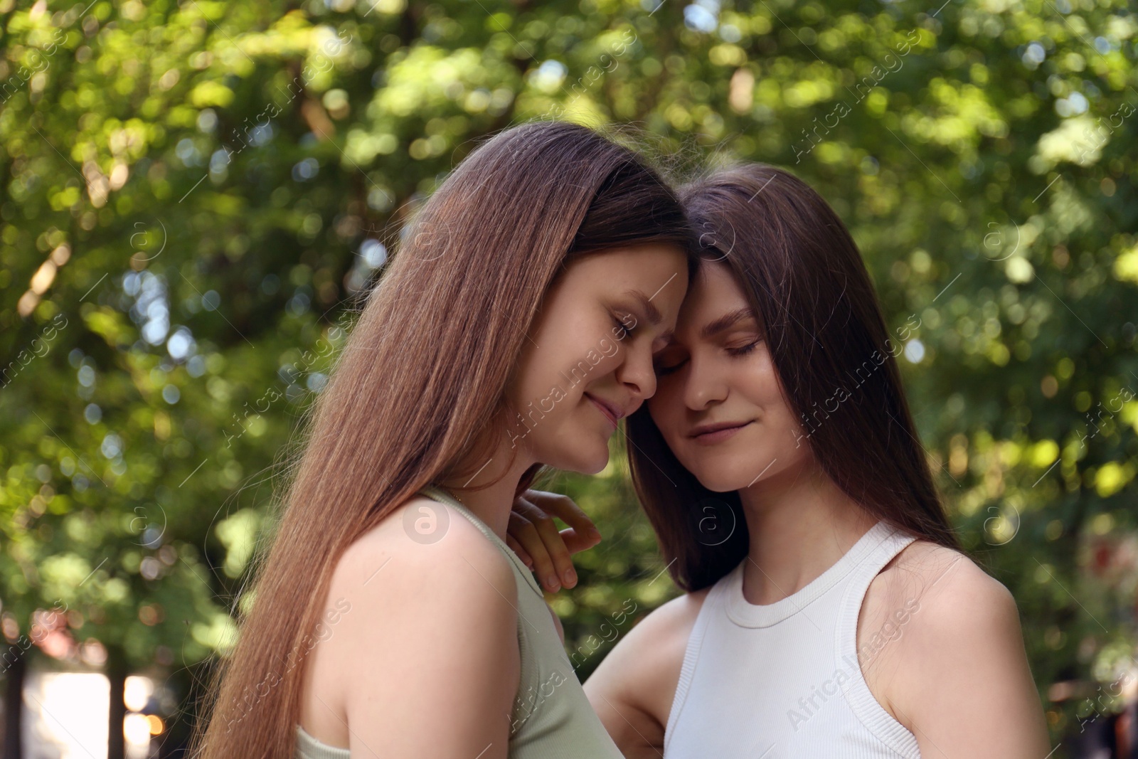 Photo of Portrait of two beautiful twin sisters in park