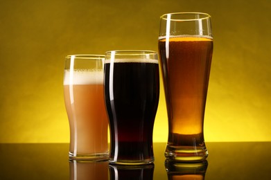 Glasses with different types of beer on dark table