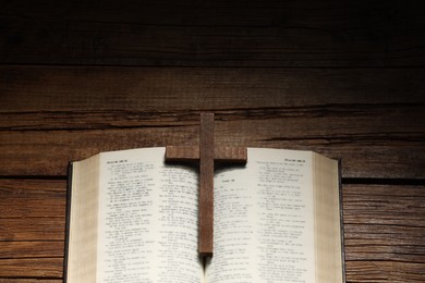 Bible and cross on wooden table, above view with space for text. Religion of Christianity