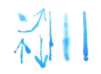 Photo of Different symbols made with light blue spray paint isolated on white, top view