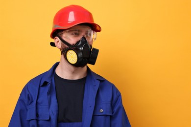 Man in respirator mask and hard hat on yellow background. Space for text