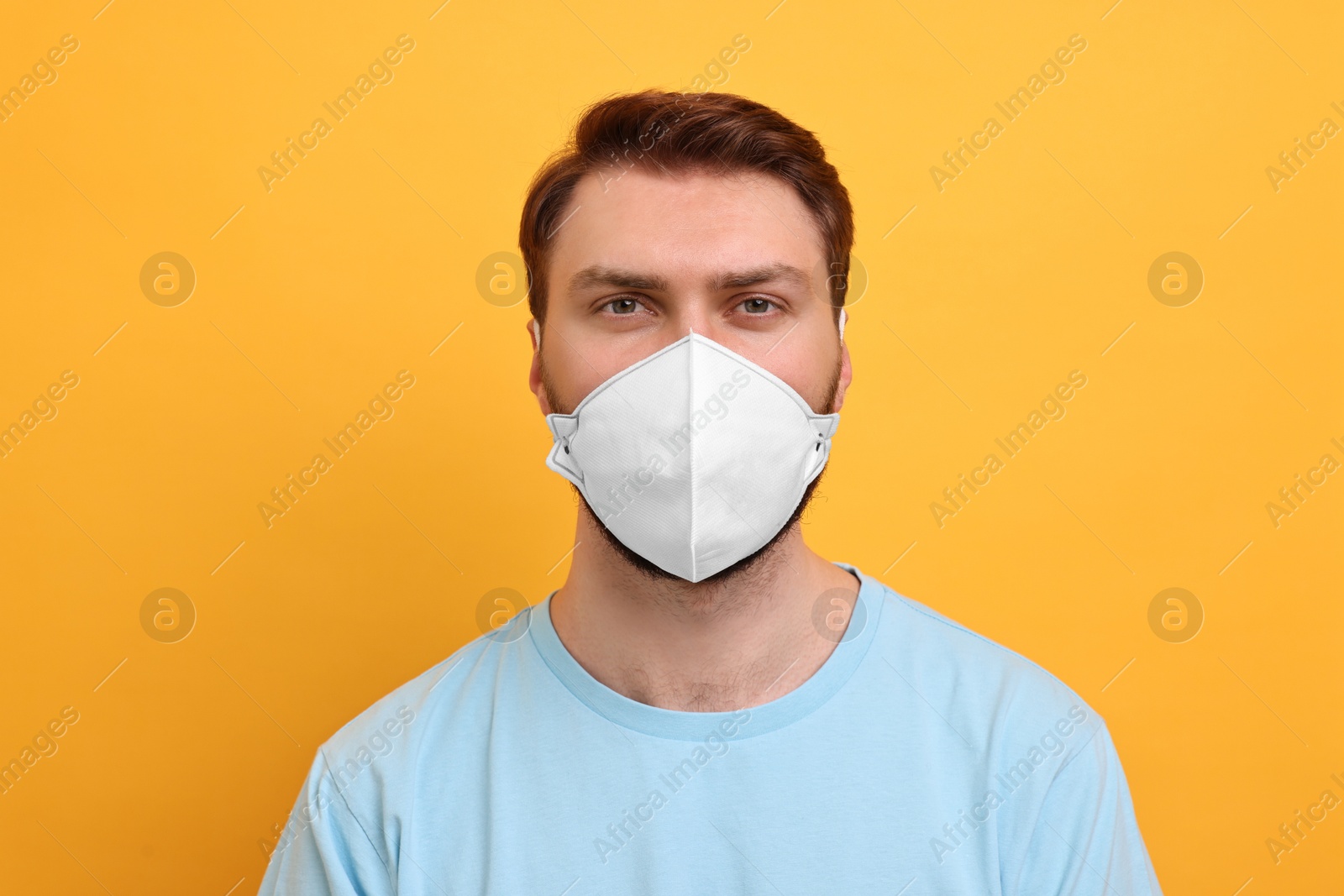 Photo of Man in respirator mask on yellow background