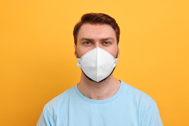 Man in respirator mask on yellow background