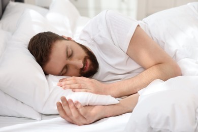 Handsome young man sleeping in bed at morning