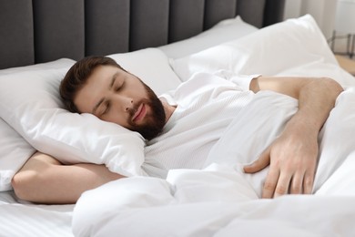 Handsome young man sleeping in bed at morning