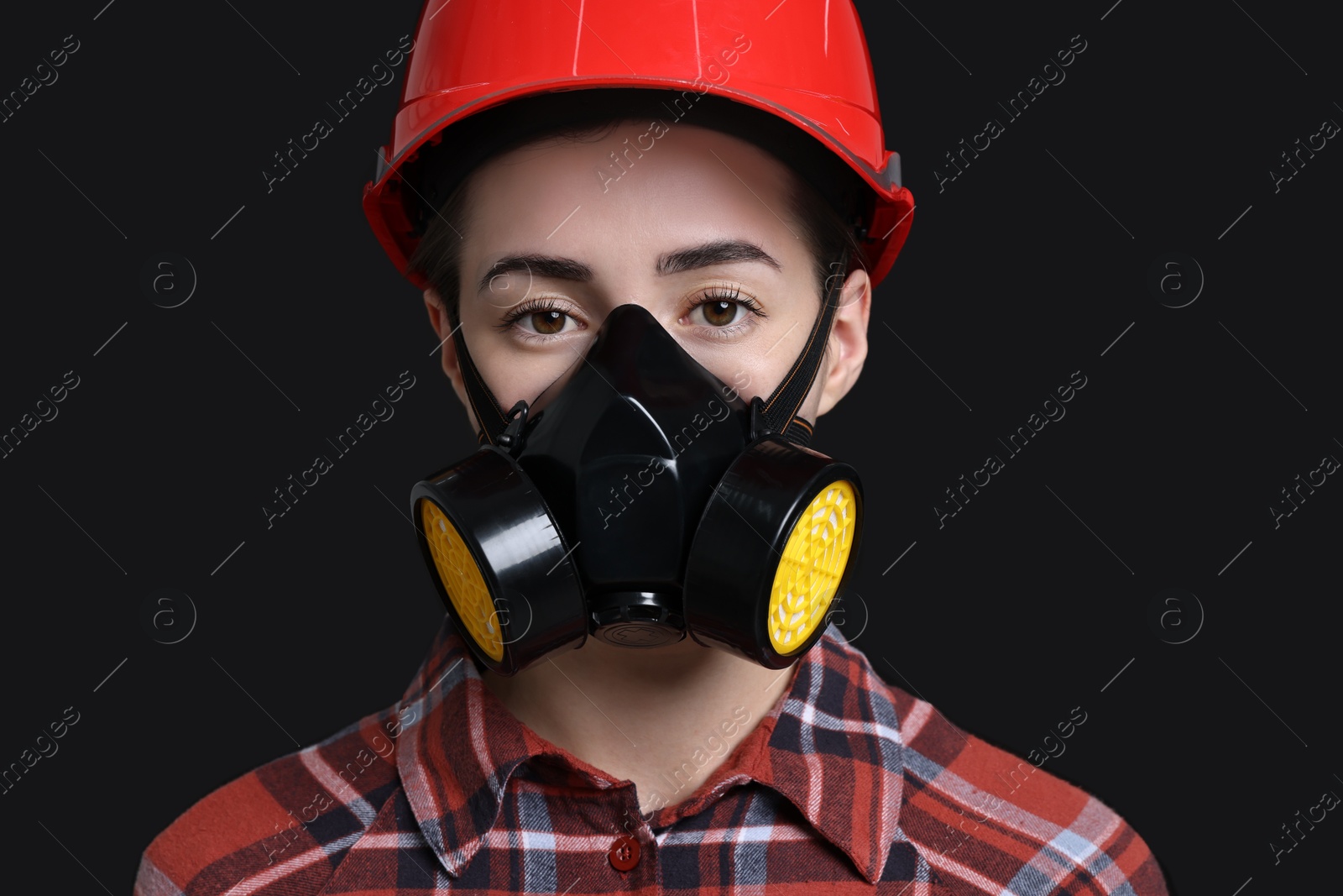 Photo of Woman in respirator and helmet on black background