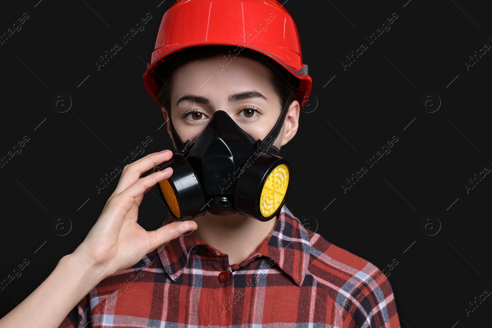 Photo of Woman in respirator and helmet on black background