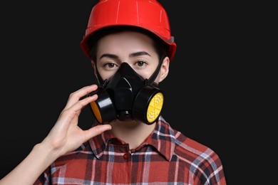 Photo of Woman in respirator and helmet on black background