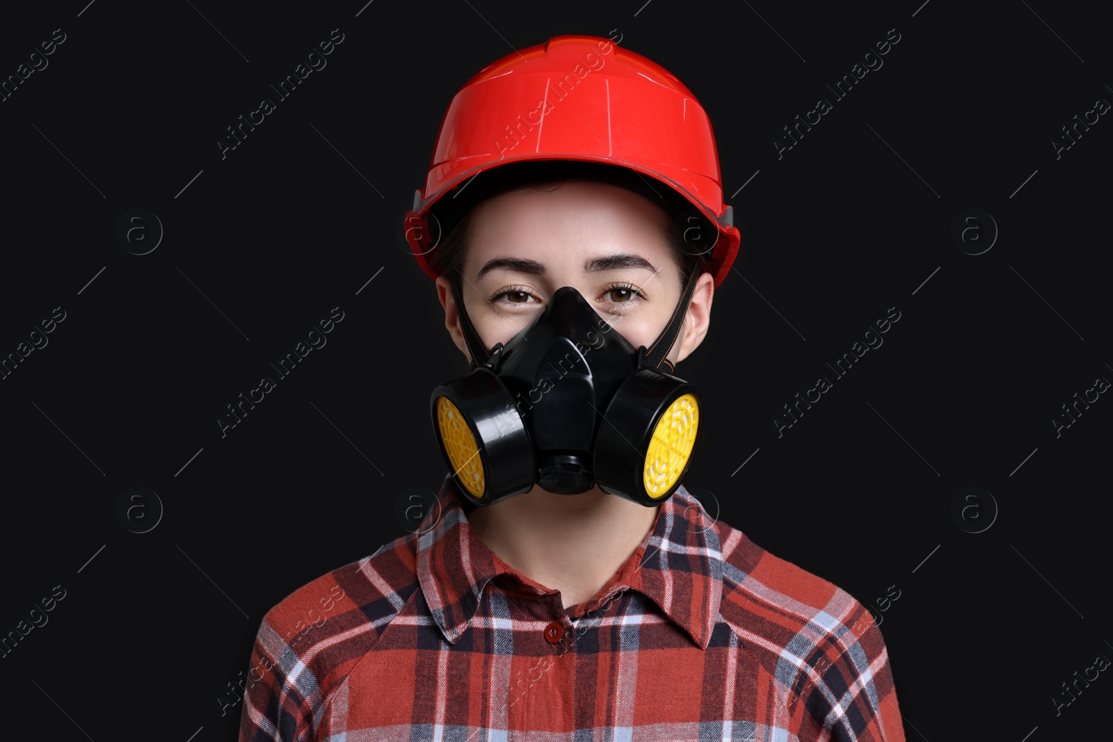 Photo of Woman in respirator and helmet on black background