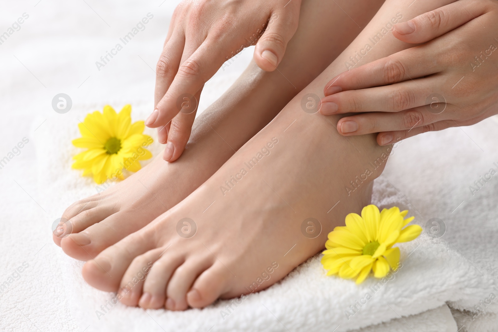 Photo of Closeup view of woman`s groomed feet after care procedure on soft towel