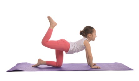 Cute little girl doing gymnastic exercise on white background