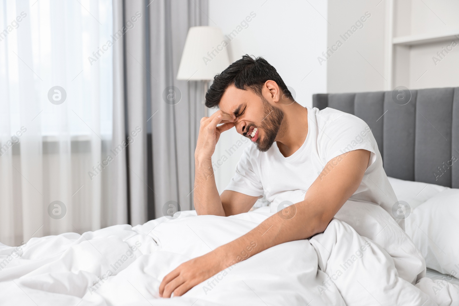 Photo of Morning of man suffering from headache in bed