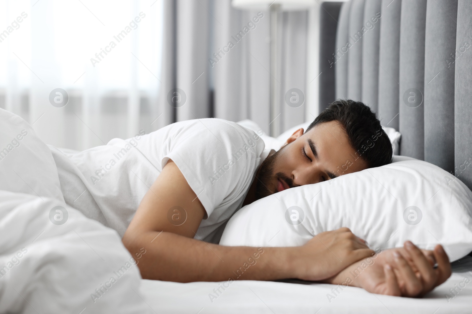 Photo of Handsome man sleeping in bed at morning